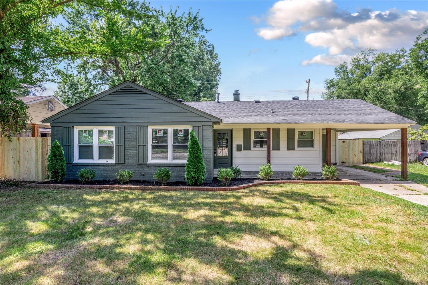 4903 Quince Road Memphis, TN 38117 - Photo 1 of 20 Ranch-style home featuring a shingled roof, a carport, a porch, and brick siding