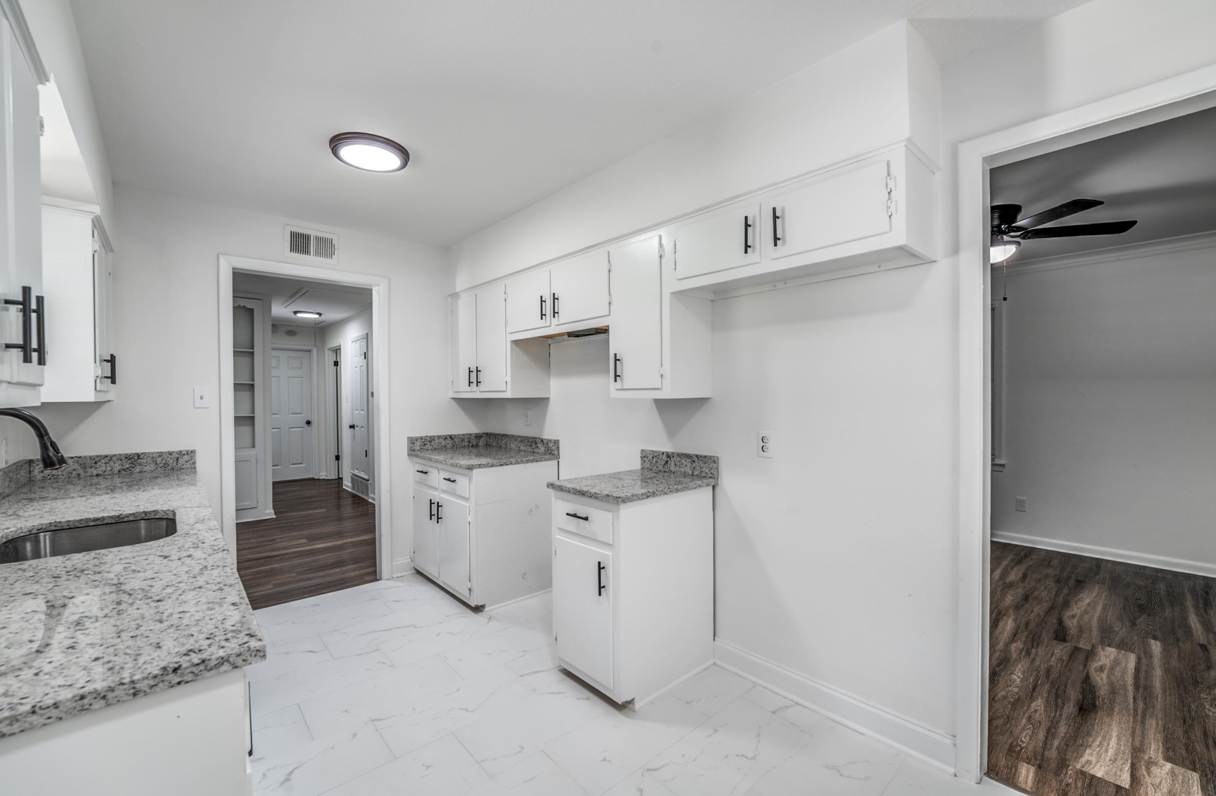 4903 Quince Road Memphis, TN 38117 - Photo 11 of 20 Kitchen featuring light marble finish floors, light stone counters, white cabinets, and a ceiling fan