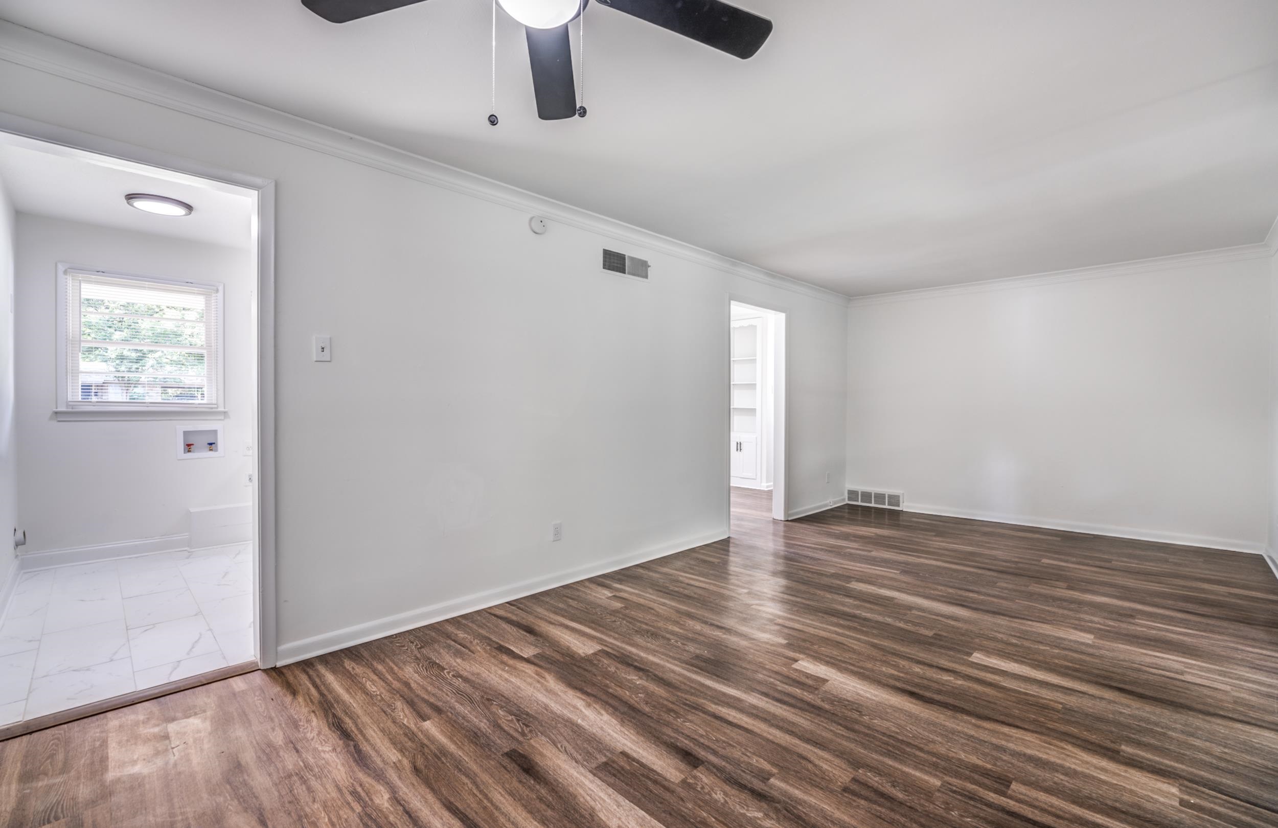 4903 Quince Road Memphis, TN 38117 - Photo 7 of 20 Unfurnished room featuring dark wood-style flooring, crown molding, and a ceiling fan