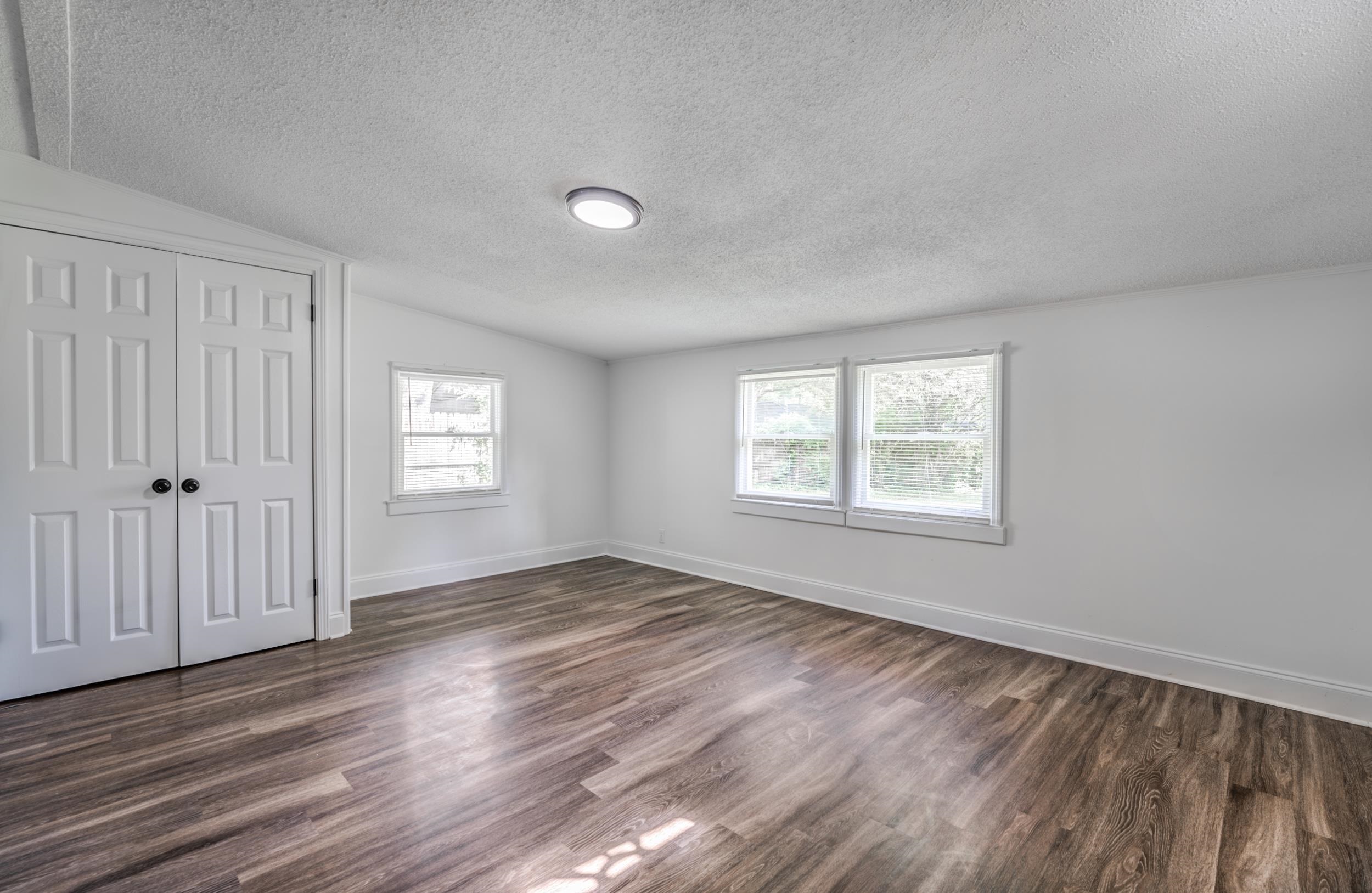 4903 Quince Road Memphis, TN 38117 - Photo 8 of 20 Unfurnished bedroom featuring a textured ceiling, lofted ceiling, a closet, and dark wood-style flooring
