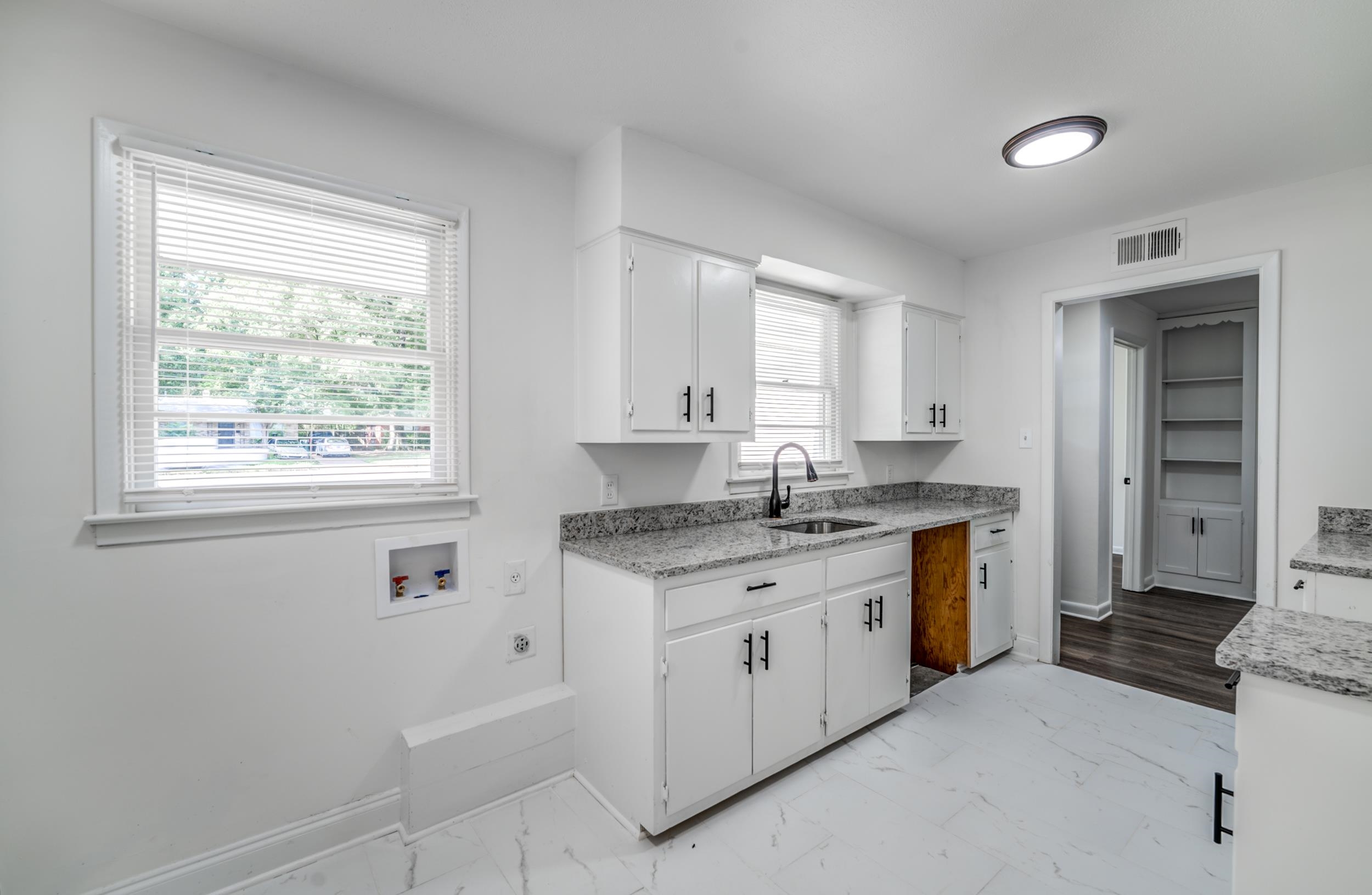 4903 Quince Road Memphis, TN 38117 - Photo 10 of 20 Kitchen featuring light marble finish floors, white cabinets, and light stone counters
