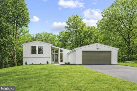 a front view of a house with a garden and yard