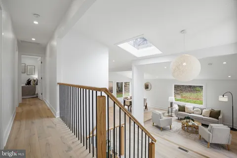 a view of a hallway to a livingroom with furniture and stairs