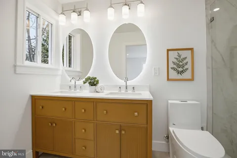 a bathroom with a toilet a sink and mirror