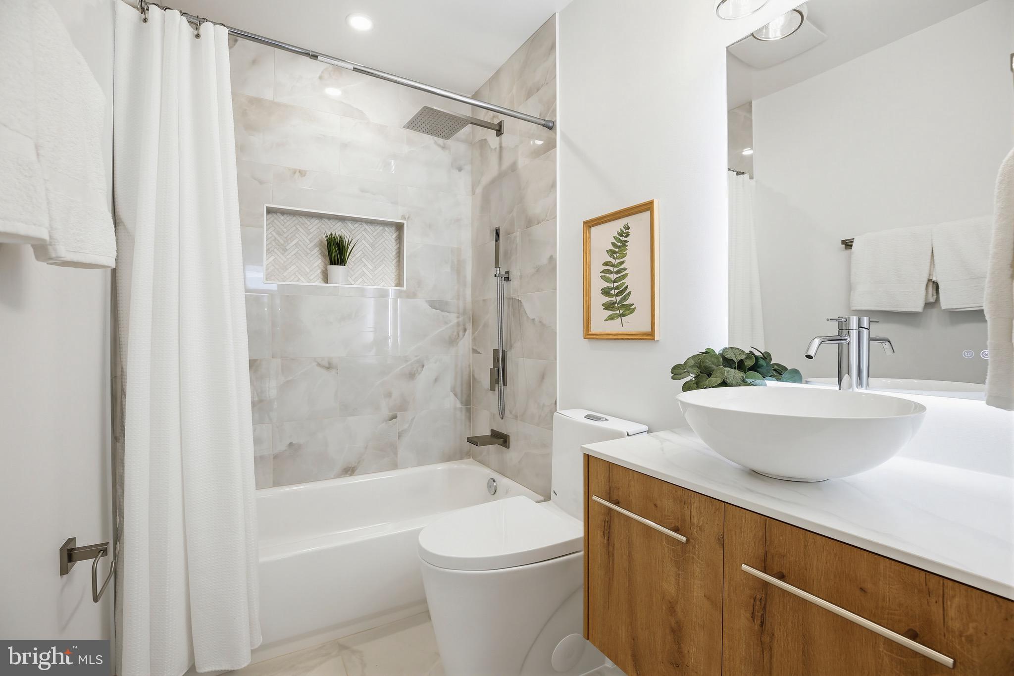 14828 Fireside Drive Silver Spring, MD 20905 - Photo 21 of 54 a bathroom with a sink a toilet a mirror a bathtub and shower