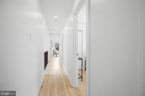 a view of a hallway with wooden floor