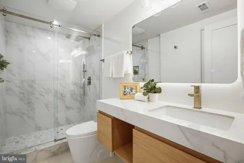 a bathroom with a sink a toilet and shower