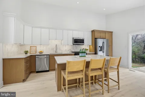 a white kitchen with a sink and white cabinets