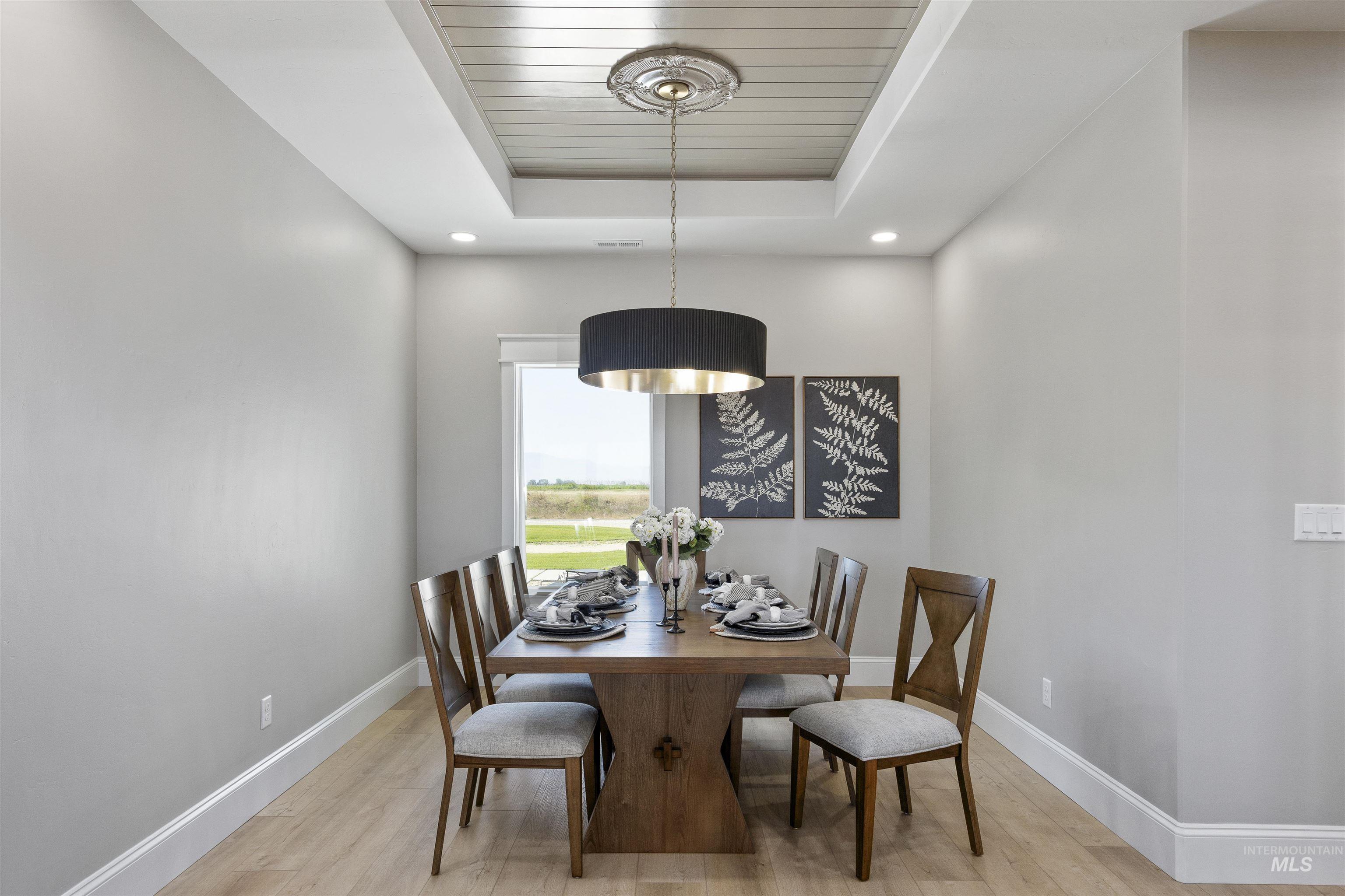378 West 100 South Rupert, ID 83350 - Photo 18 of 50 Dining area featuring a wood-finish flooring, recessed lighting, and a tray ceiling with a central drum pendant light