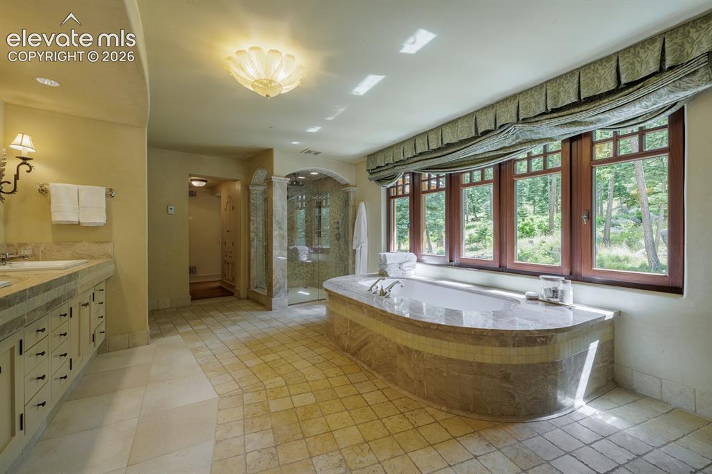 4530 Governors Point Colorado Springs, CO 80906 - Photo 13 of 49 Primary suite spa/bathroom with large soaking Jacuzzi tub and cabinetry with inlaid leather