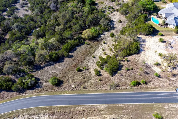 an aerial view of ocean and residential houses with outdoor space