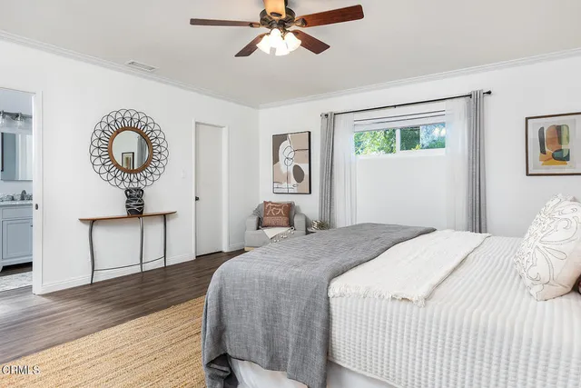a bedroom with a bed mirror and a window