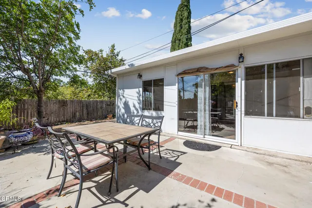 a view of a dinning table and chairs in patio of the house