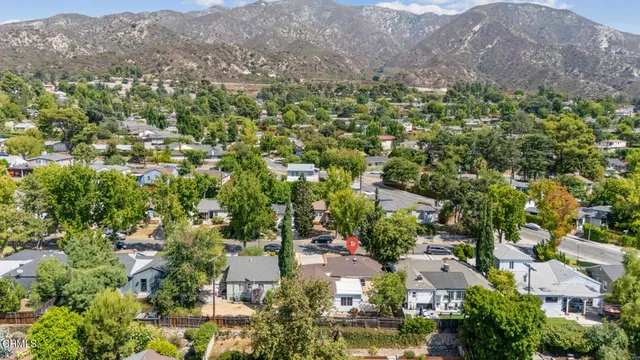 an aerial view of residential houses with outdoor space and trees