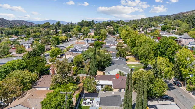 an aerial view of residential houses with outdoor space and trees