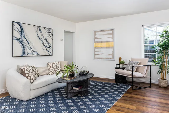 a living room with furniture a couch and paintings on the wall