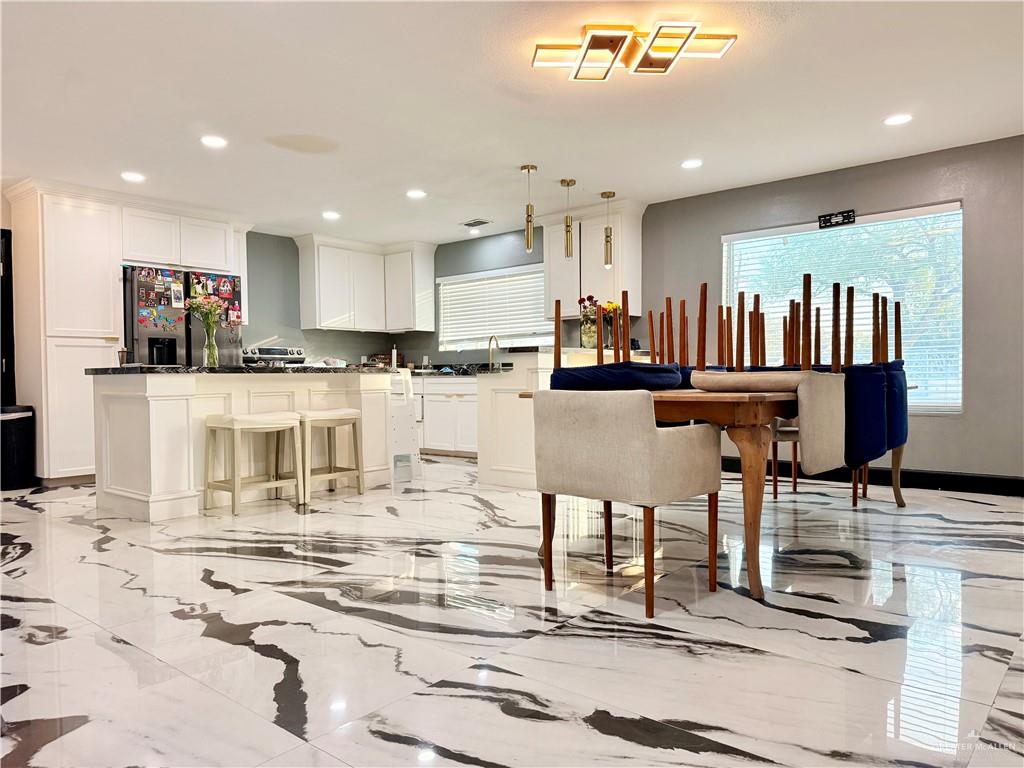 940 West Mile 3 Road Mission, TX 78573 - Photo 13 of 25 a kitchen with stainless steel appliances kitchen island granite countertop a refrigerator and cabinets
