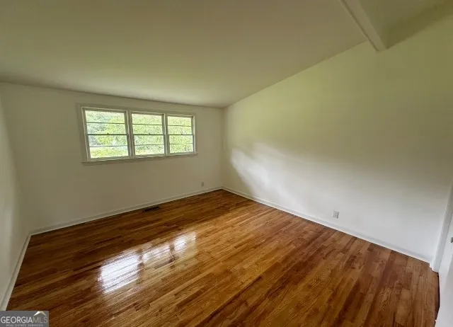 a bathroom with a granite countertop sink a toilet a mirror and shower