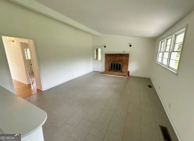 a view of a livingroom with a fireplace and window