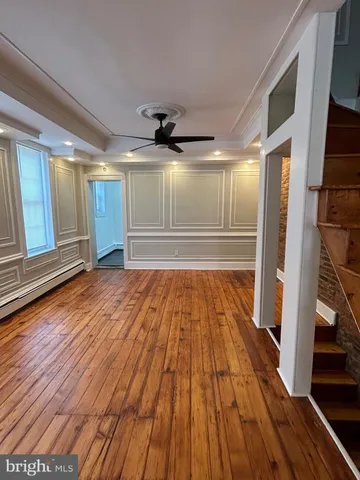 a view of empty room with wooden floor
