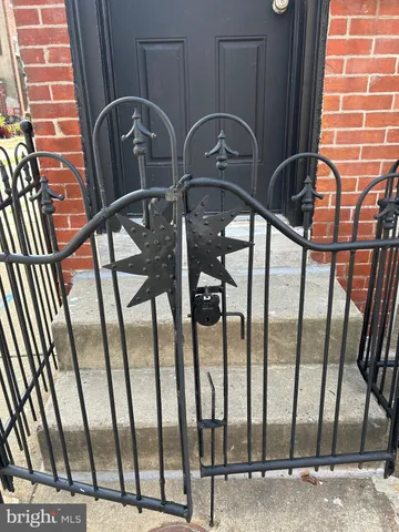 a view of an empty room with wooden floor fireplace and a window