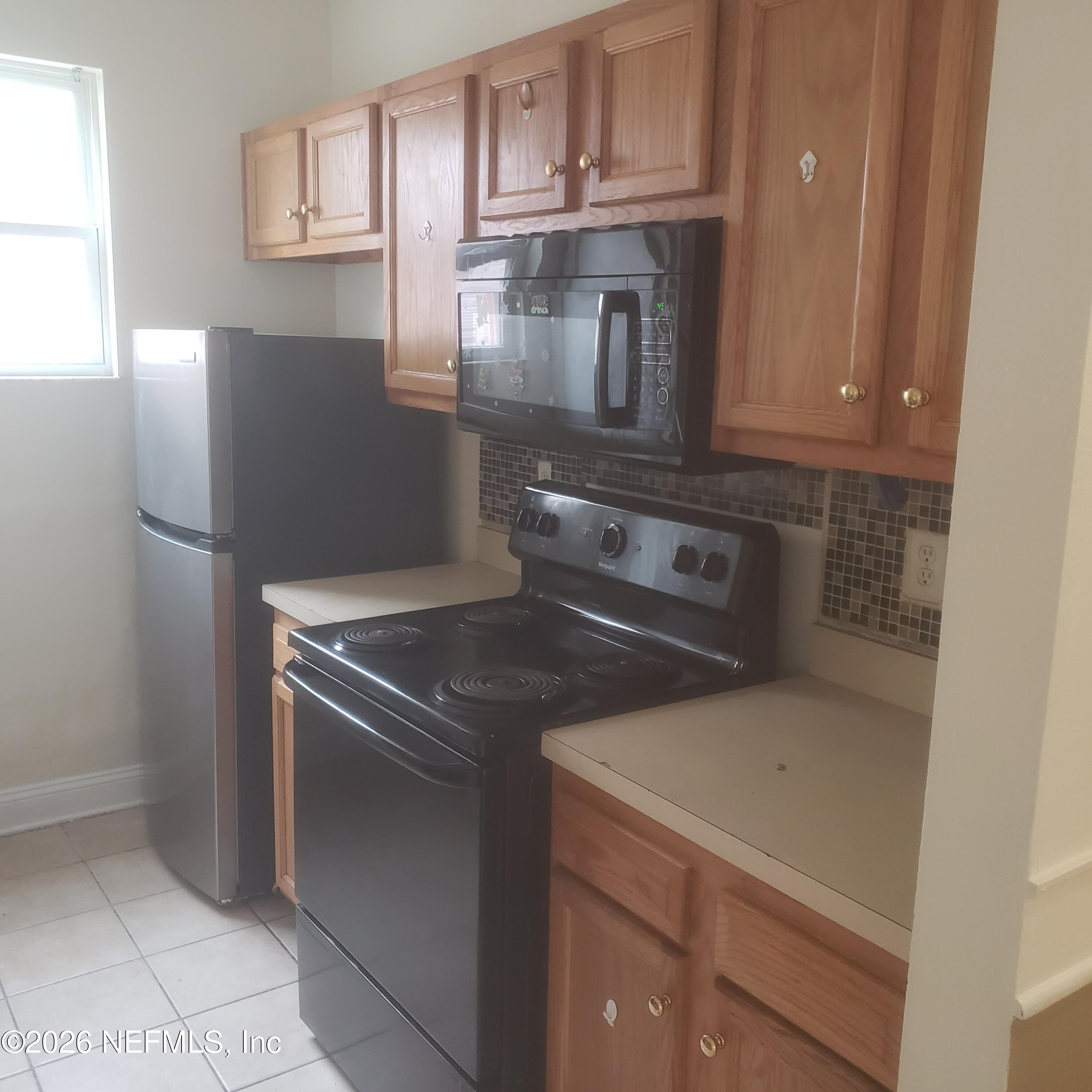 1530 West 29th Street Jacksonville, FL 32209 - Photo 5 of 12 a kitchen with stainless steel appliances granite countertop a refrigerator a stove and a sink