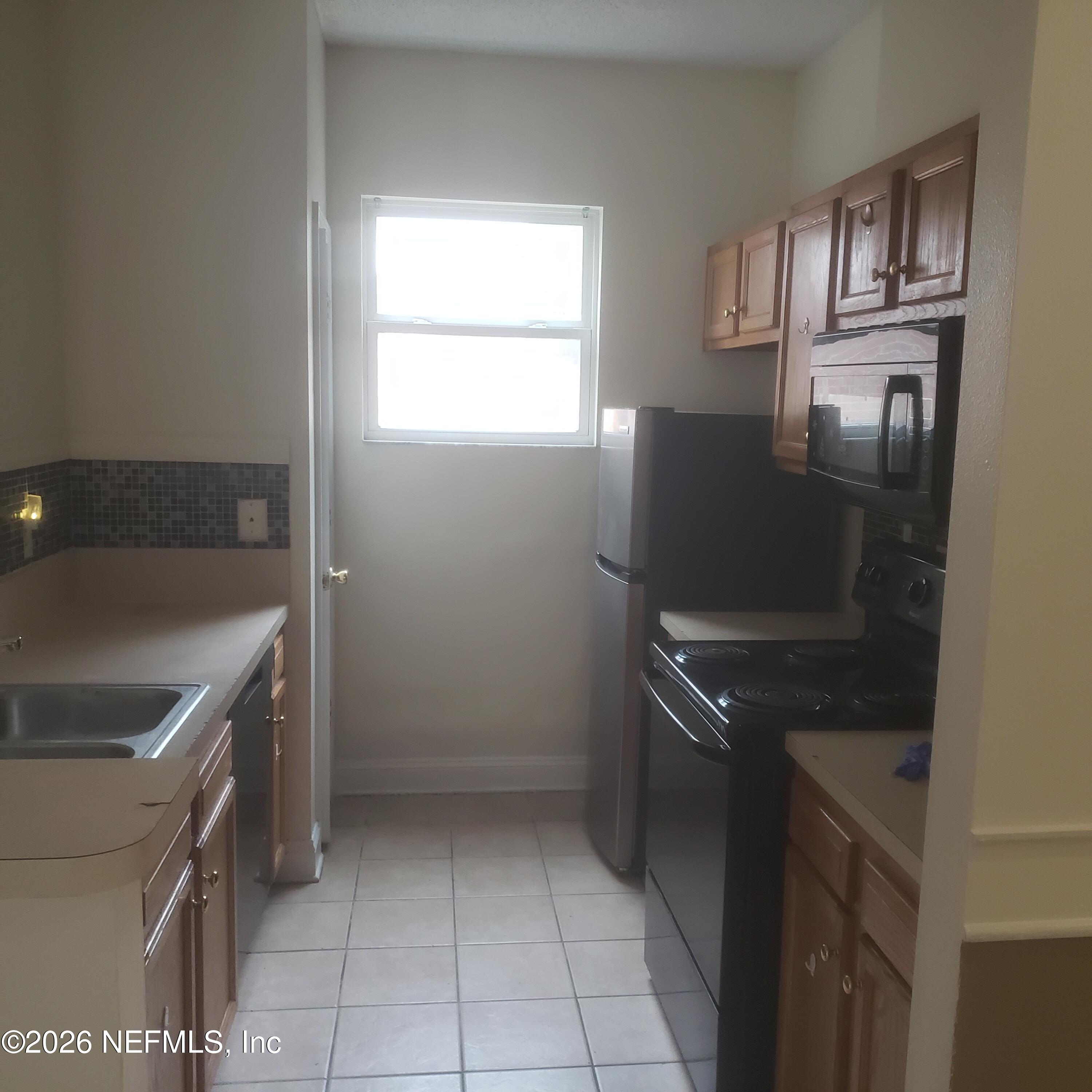 1530 West 29th Street Jacksonville, FL 32209 - Photo 6 of 12 a kitchen with a sink a stove and cabinets