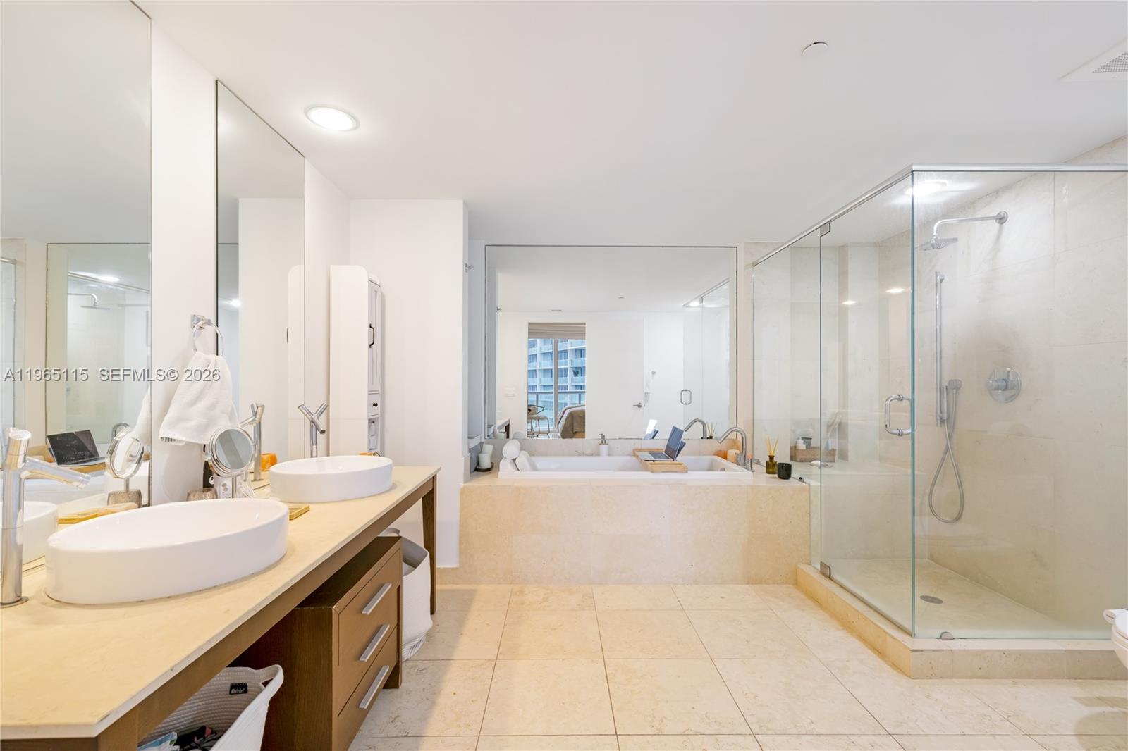 495 Brickell Avenue, Unit 4704 Miami, FL 33131 - Photo 14 of 24 a large bathroom with a double vanity sink a large mirror and shower