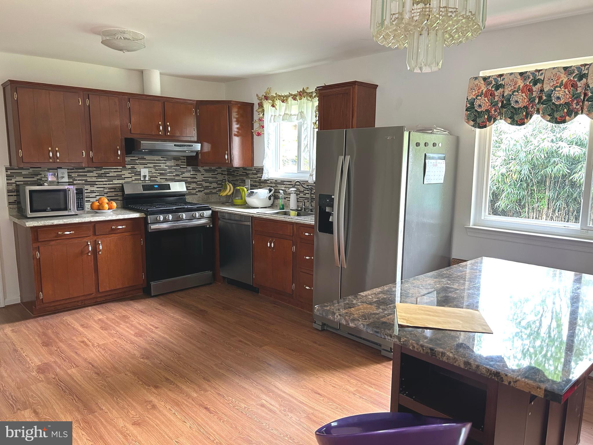 5606 Ventnor Lane Springfield, VA 22151 - Photo 6 of 24 a kitchen with stainless steel appliances granite countertop a refrigerator a sink a stove and a wooden floors