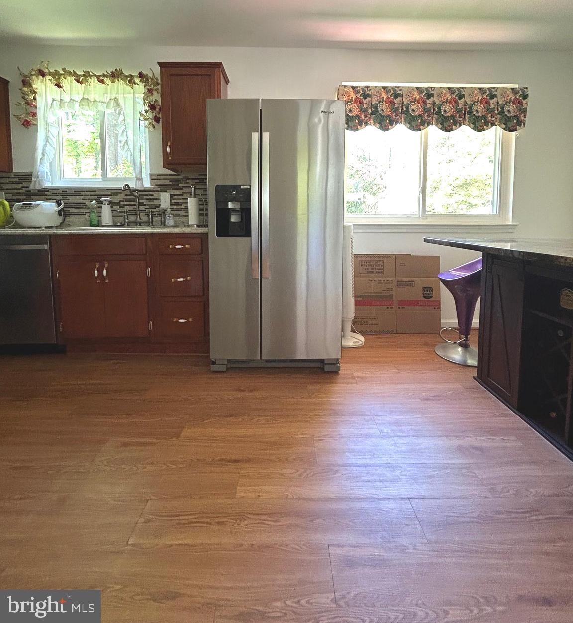 5606 Ventnor Lane Springfield, VA 22151 - Photo 7 of 24 a open kitchen with granite countertop a refrigerator and a stove top oven