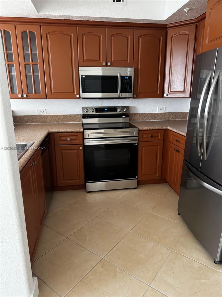 2301 Southwest 27th Avenue, Unit 503 Miami, FL 33145 - Photo 7 of 24 a kitchen with granite countertop a refrigerator stove and microwave