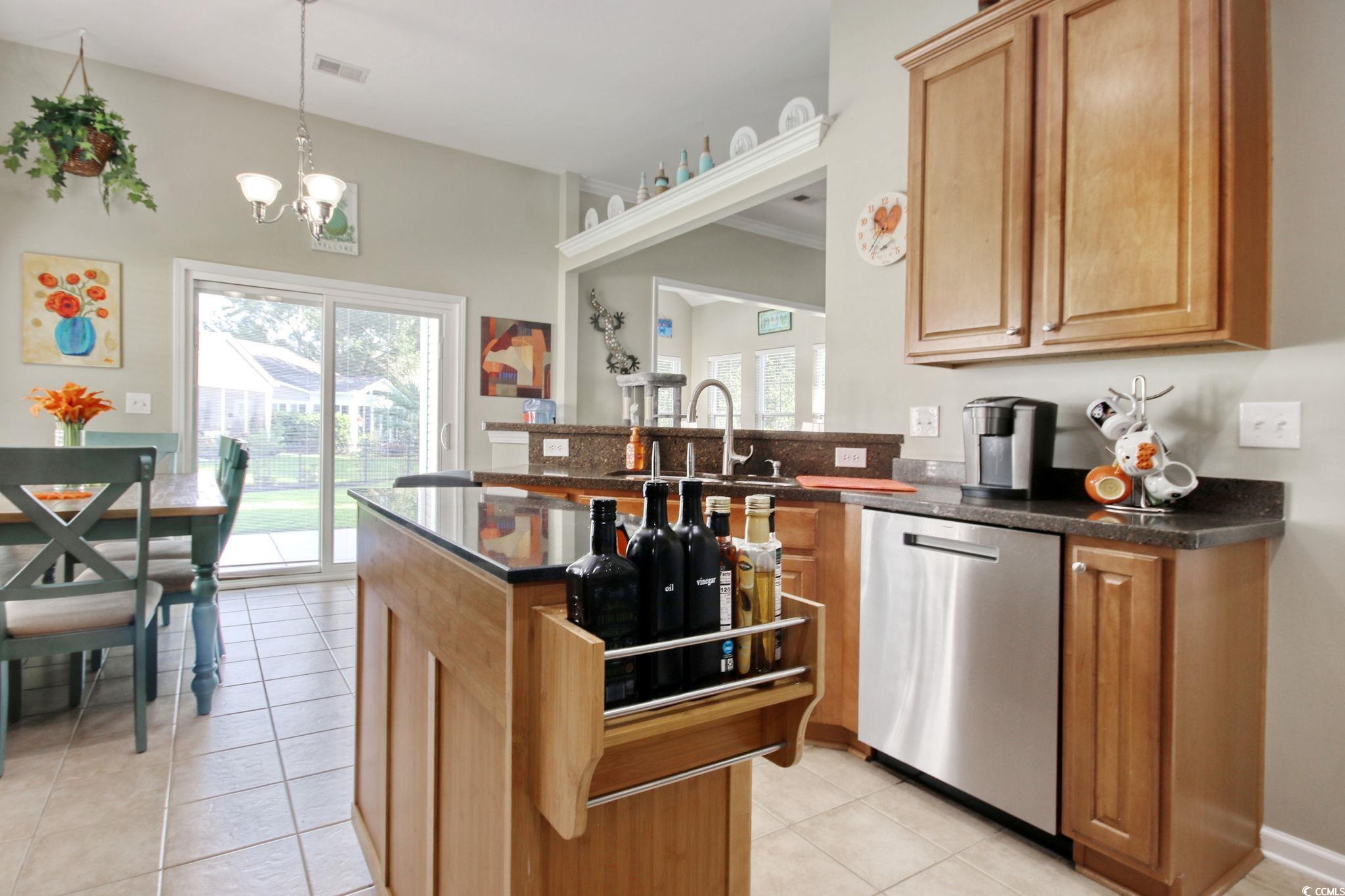 47 Pinfeather Drive Murrells Inlet, SC 29576 - Photo 12 of 35 Kitchen with a peninsula, dishwasher, decorative light fixtures, light tile patterned floors, and dark stone counters