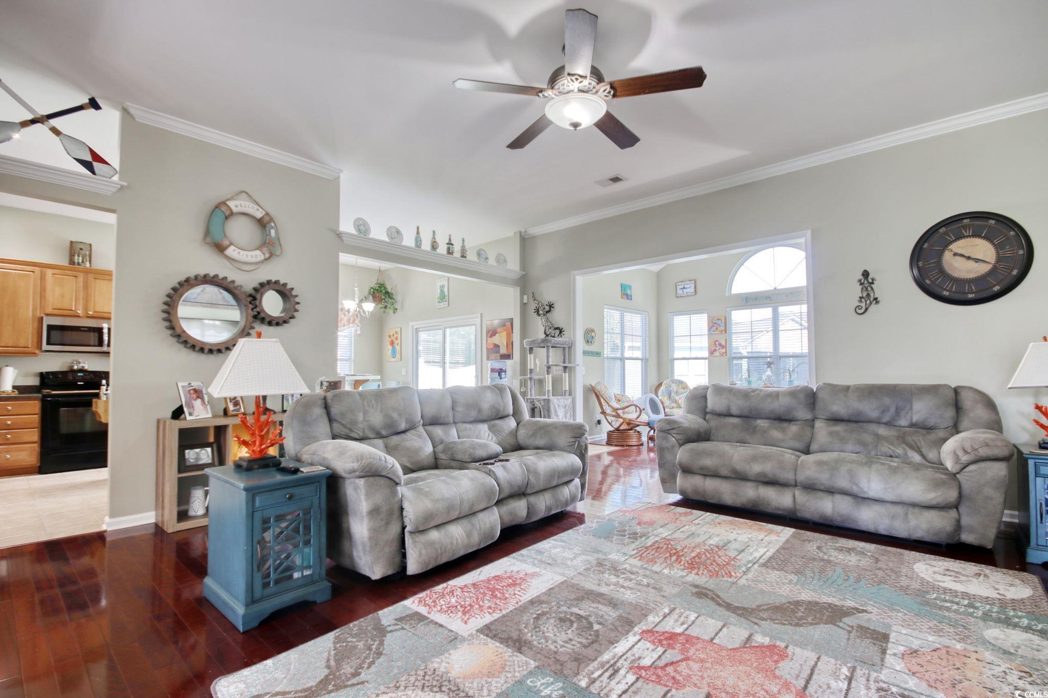 47 Pinfeather Drive Murrells Inlet, SC 29576 - Photo 7 of 35 Living room featuring a ceiling fan, plenty of natural light, ornamental molding, and dark wood-style flooring