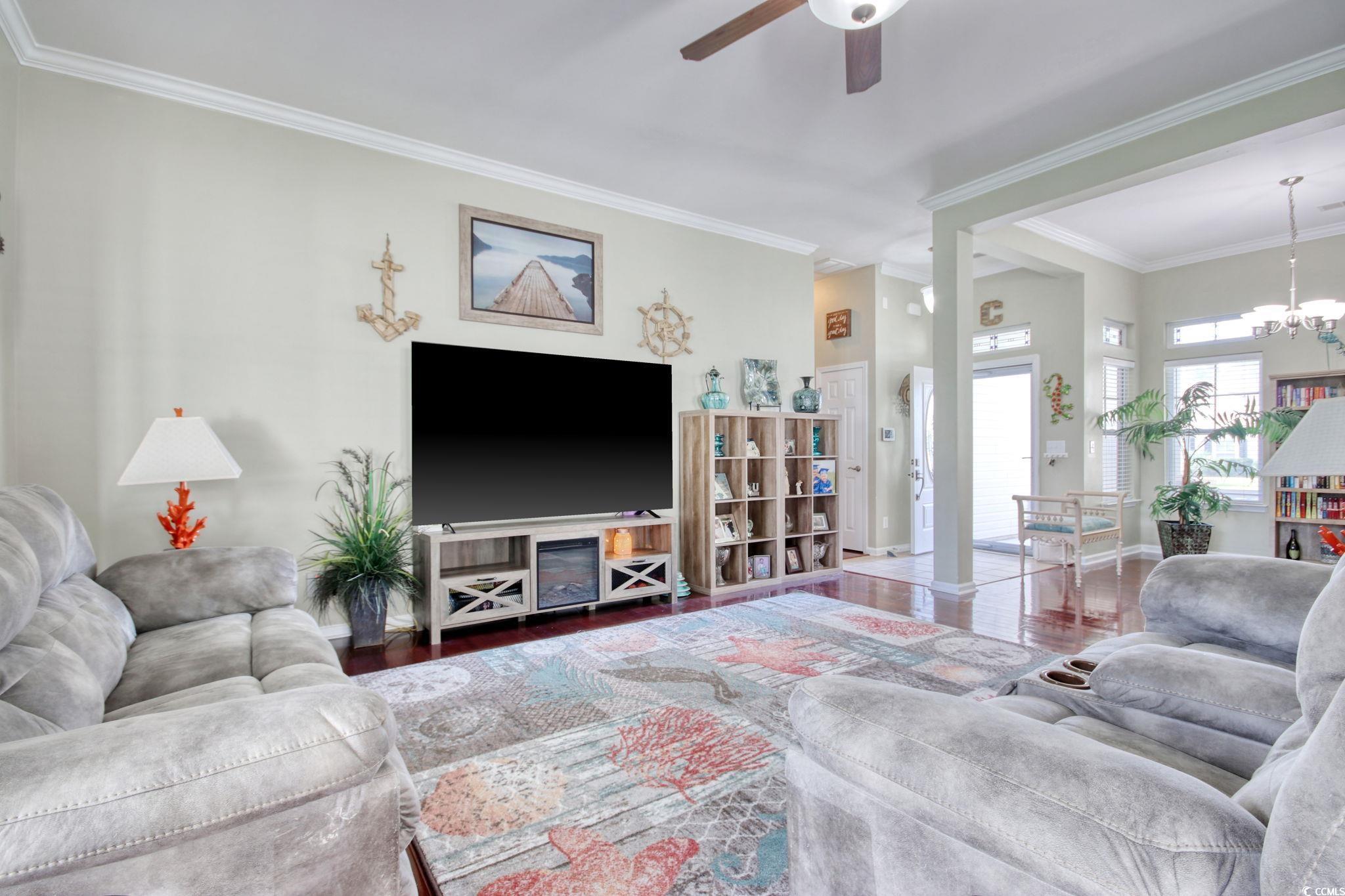 47 Pinfeather Drive Murrells Inlet, SC 29576 - Photo 8 of 35 Living area with wood finished floors, ornamental molding, a chandelier, and ceiling fan