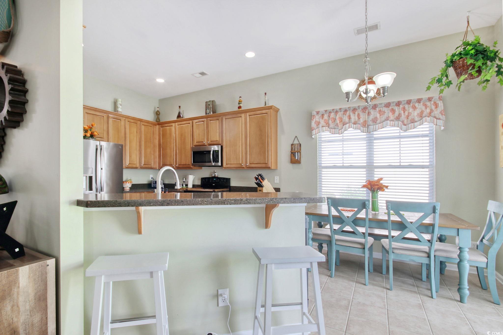 47 Pinfeather Drive Murrells Inlet, SC 29576 - Photo 10 of 35 Kitchen featuring hanging light fixtures, appliances with stainless steel finishes, light tile patterned floors, a breakfast bar area, and recessed lighting