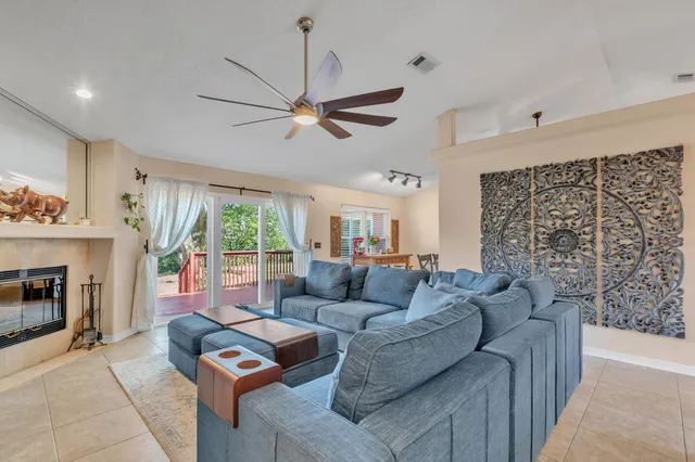 a living room with furniture a fireplace and a large window