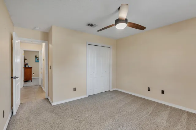 an empty room with a ceiling fan and a window