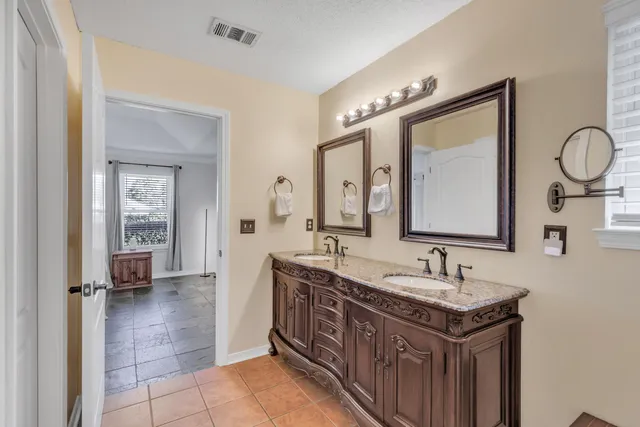 a bathroom with a double vanity sink and a mirror