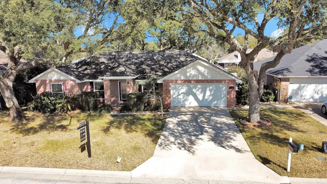 a view of a house with large tree in front of it