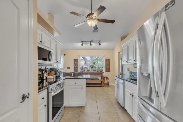 a kitchen with white cabinets and appliances