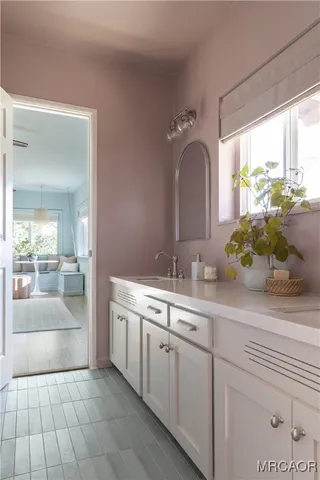 a large white kitchen with a sink and dish washer