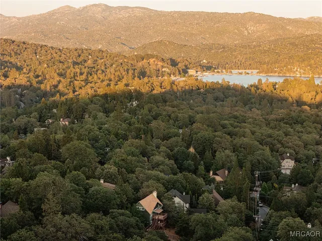 an aerial view of residential houses with outdoor space and ocean view