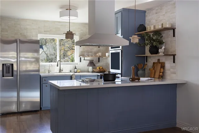 a kitchen with stainless steel appliances granite countertop a sink a stove and a refrigerator