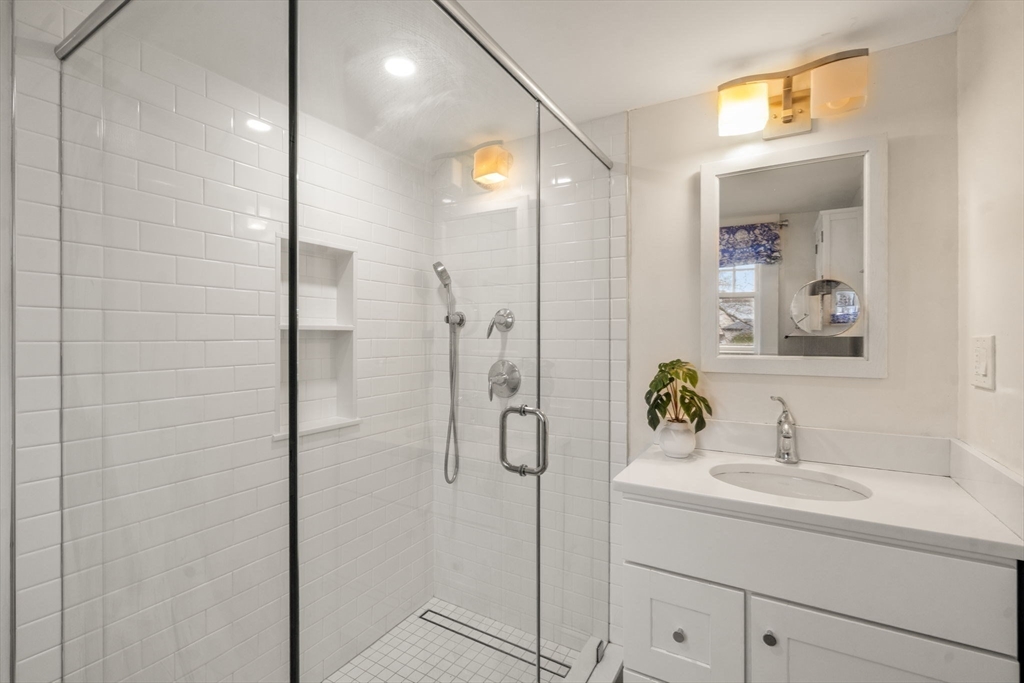 12 Leighton Road Wellesley, MA 02482 - Photo 19 of 34 a bathroom with a shower sink and mirror