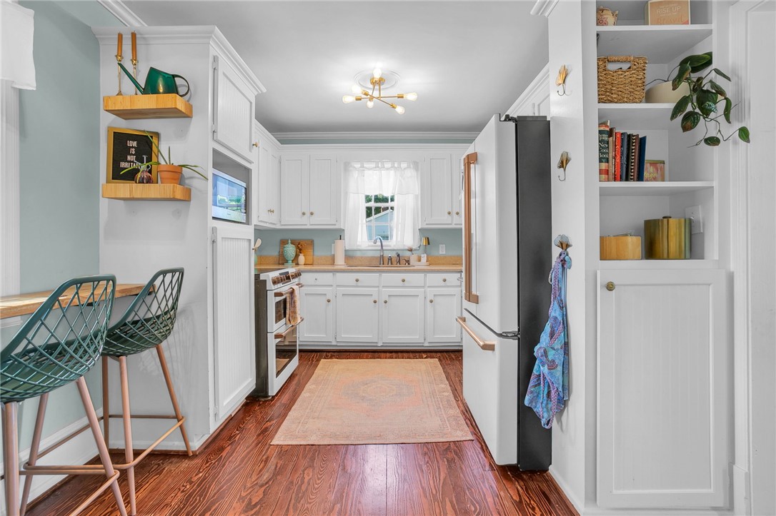 1107 Springdale Road Anderson, SC 29621 - Photo 16 of 49 This charming kitchen boasts elegant wooden flooring and a window over the sink, creating a bright and inviting space.