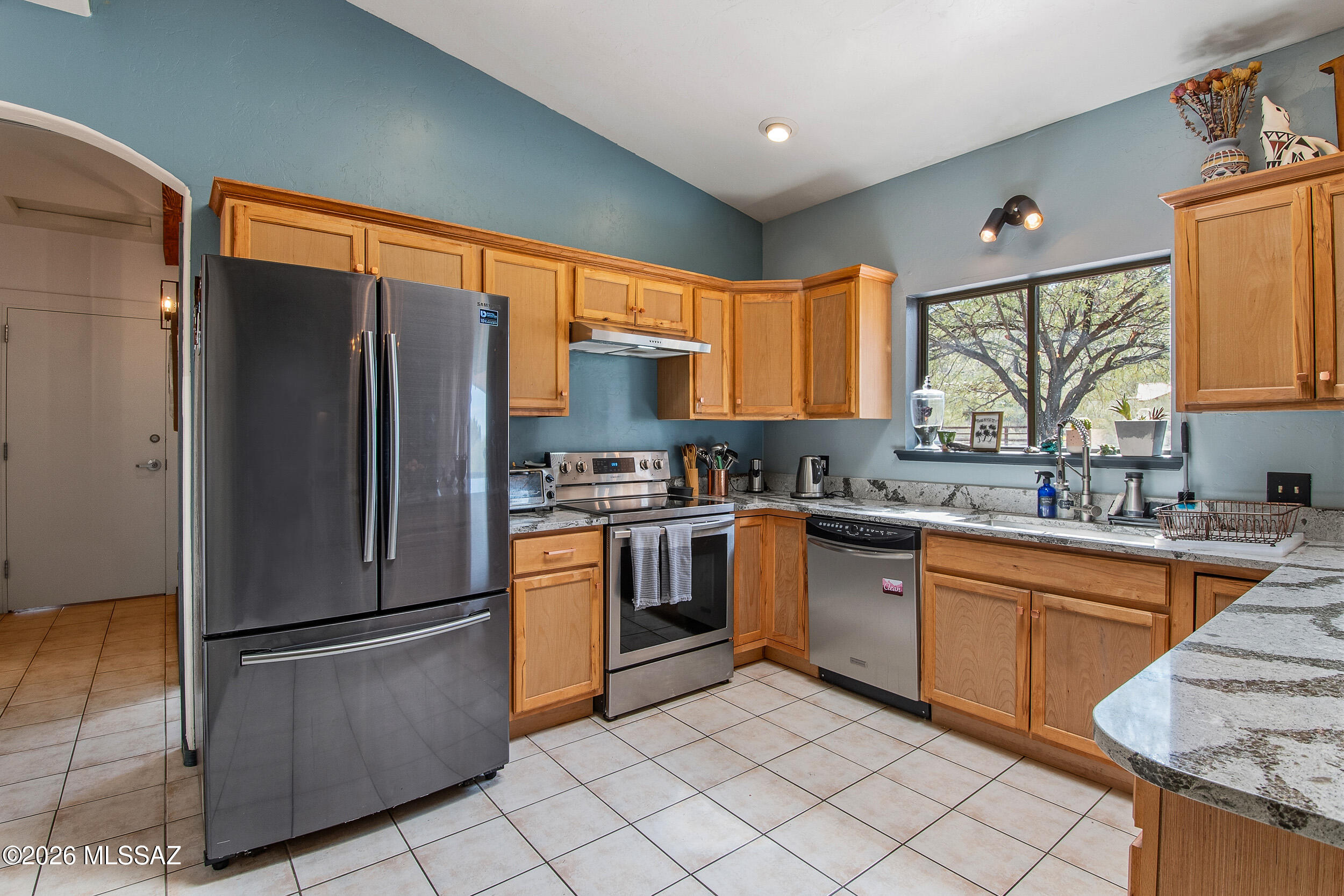 4155 West Coyote Ridge Trail Tucson, AZ 85746 - Photo 23 of 39 a kitchen with granite countertop stainless steel appliances a refrigerator cabinets and a sink