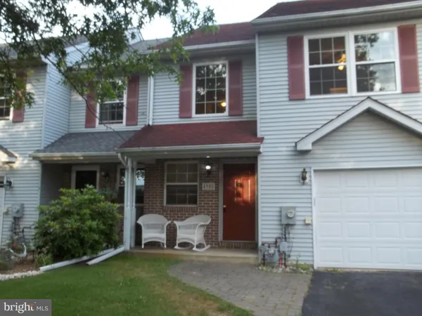 a front view of a house with a garden and plants
