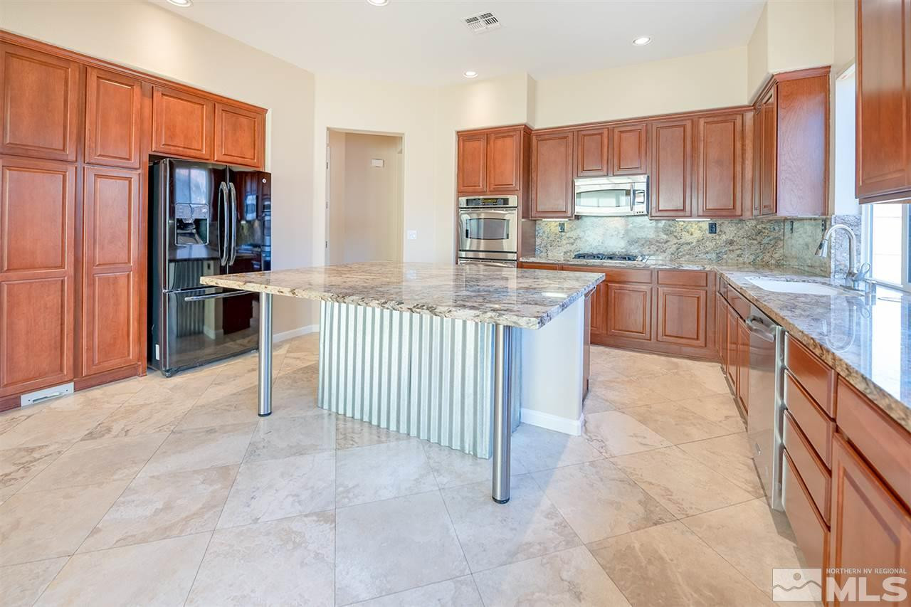 10645 Summer Glen Drive Reno, NV 89521 - Photo 11 of 25 a kitchen with stainless steel appliances granite countertop a stove top oven a sink and dishwasher