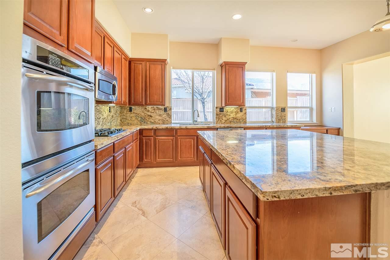 10645 Summer Glen Drive Reno, NV 89521 - Photo 13 of 25 a large kitchen with stainless steel appliances granite countertop a large counter top and a stove