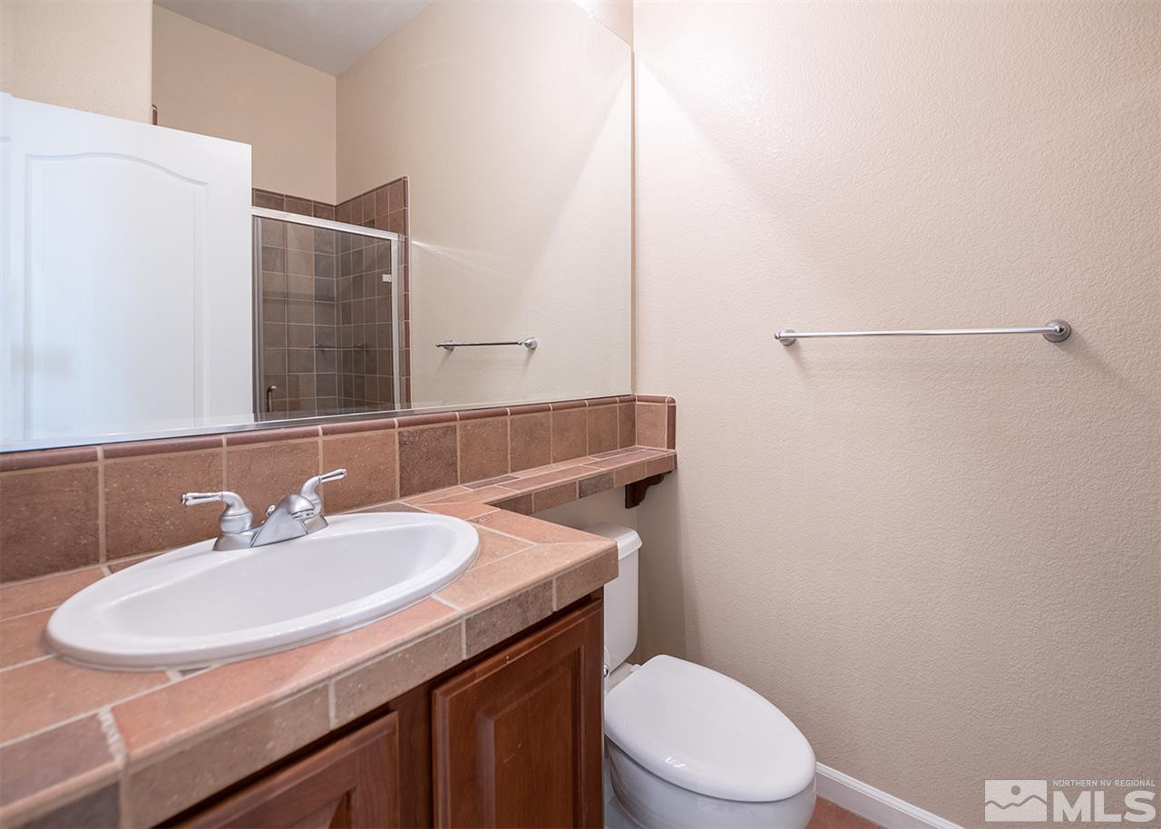 10645 Summer Glen Drive Reno, NV 89521 - Photo 18 of 25 a bathroom with a sink a toilet and mirror